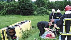 Autobus, pod kterým se utrhla krajnice, se převrátil na bok. Ženě, která při nehodě autobusu utrpěla smrtelná zranění, záchranáři již pomoci nemohli
 