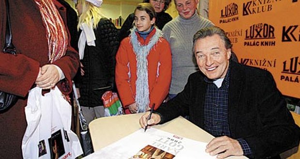 Karel Gott trpělivě podepisoval přední stranu kalendáře, na němž se skví i logo Blesku