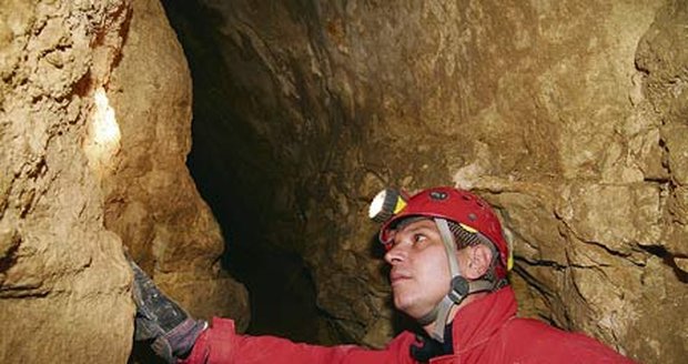 Speleolog prozkoumává podzemní chodbu