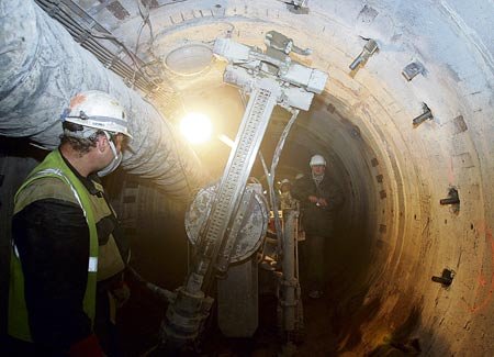Razicí stroj v čele kolektorové chodby. Vyrubaný prostor se musí vyztužit, zabezpečit a pak osadit potřebnými technologiemi