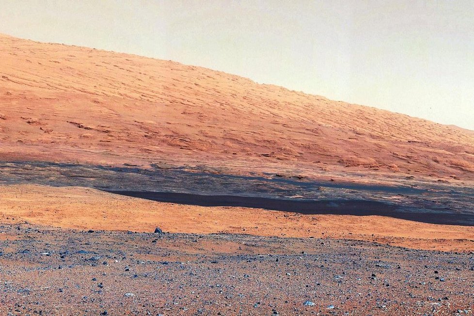 Impozantní fotografie zachycují spodní části pět kilometrů vysoké hory zdvihající se z Galeova kráteru na jižní polokouli Marsu poblíž rovníku, kde Curiosity přistála 6. srpna. Vědci odhadují, že Curiosity bude trvat asi rok, než se fyzicky dostane na úpatí hory, která je asi deset kilometrů od místa přistání. (Foto ČTK)