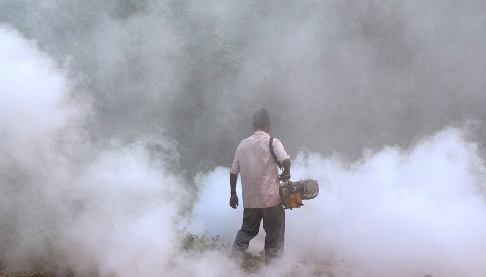 Pracovní radnice v Indii dezinfikuje kouřem oblast od komárů, kteří přenáší malárii