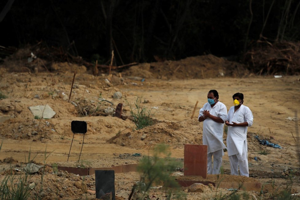 Ochranné obleky musí v Indii mít při pohřbívání i příbuzní zemřelého s covid19. (5. 6. 2020)