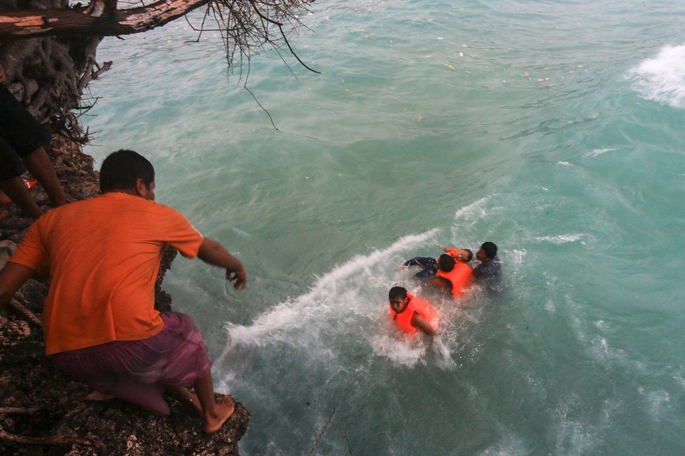 Lidé v plovoucích vestách vyskakovali z trajektu a plavali ke břehu.