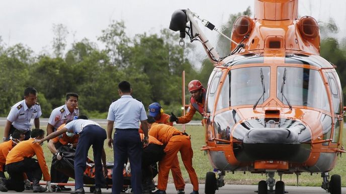 Indonéští záchranáři vykládají z vrtulníku tělo jedné z obětí pádu letadla AirAsia