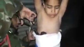 Irácký voják sundává chlapci výbušninu z těla.