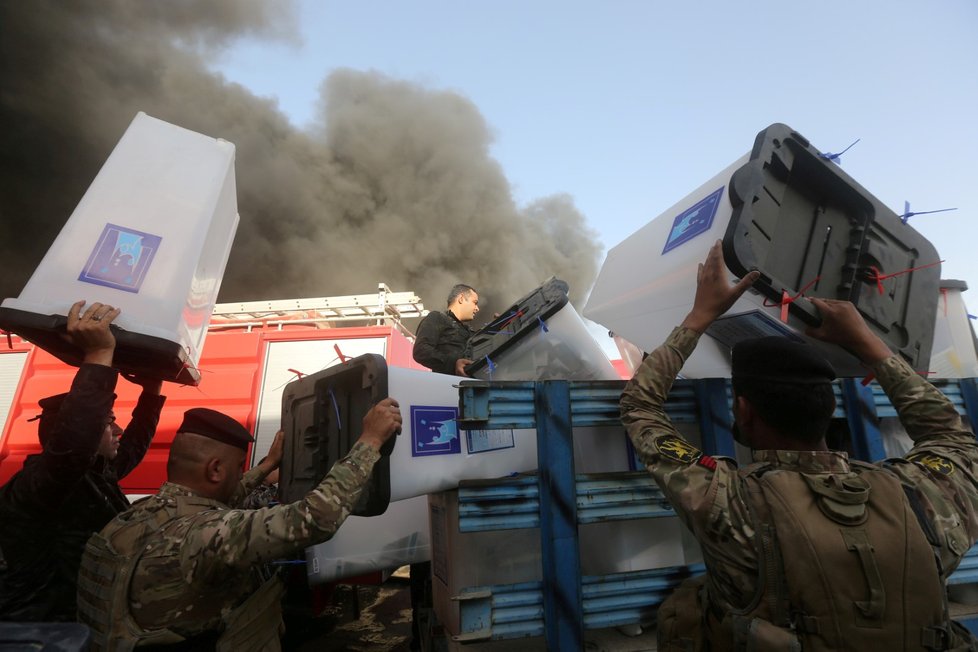 Irácké bezpečnostní složky odnáší volební urny z vyhořelého skladu.