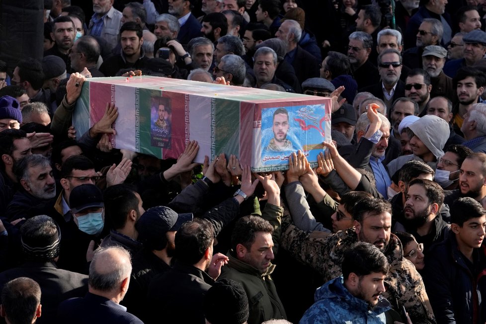 Lidé nesou rakev s vlajkou příslušníka íránských revolučních gard, který zahynul při leteckém útoku v Sýrii.