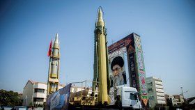 Na teheránském náměstí v popředí zbraně, v pozadí obří portrét íránského prezidenta Ruháního.