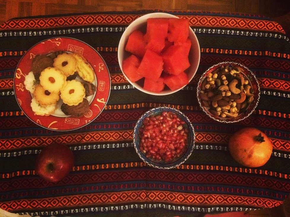 Stůl prostřený do červených barev s typickým ovocem.