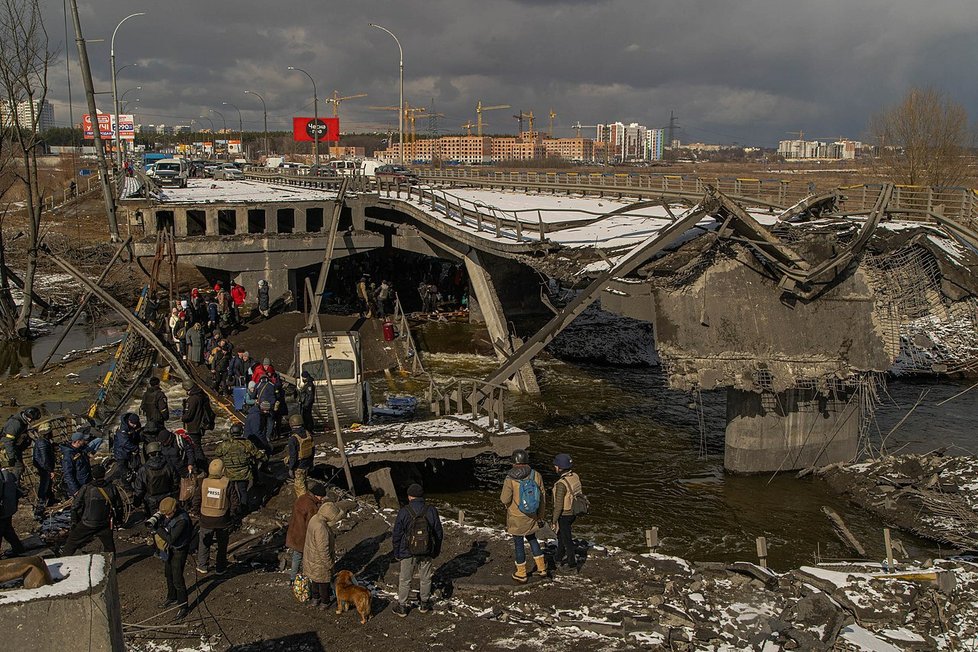 Civilisté evakuují Irpiň pod zničeným mostem přes stejnojmennou řeku (8. března 2022).