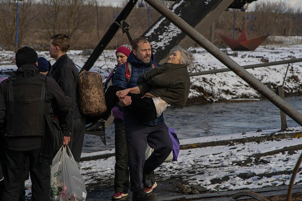 Civilisté evakuují Irpiň pod zničeným mostem přes stejnojmennou řeku (8. března 2022).