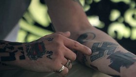Neonacista ukazuje svá tetování.