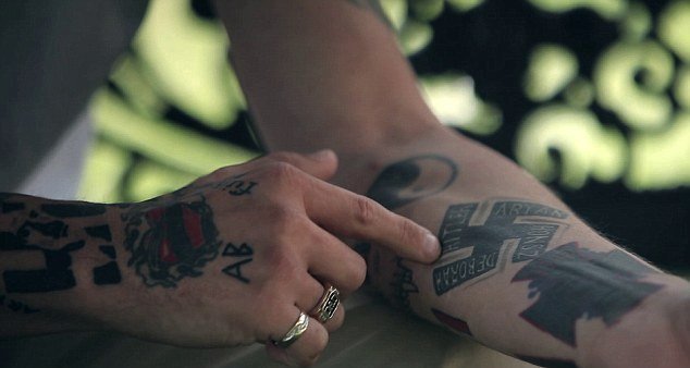 Neonacista ukazuje svá tetování.