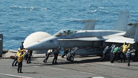 Jedna ze dvou stíhaček F / A-18C Hornet, které bombardovaly pozice radikálů z ISIS se připravuje ke startu z lodi USS George HW Bush v Perském zálivu před úsvitem.