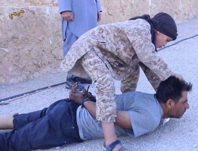 Další šokující poprava ISIS: Chlapec se vrhnul na zajatce a podřízl mu hrdlo.