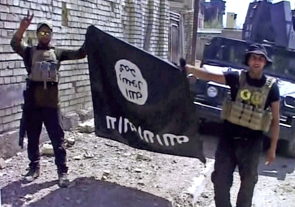 Iráští vojáci s ukořistěnou vlajkou Islámského státu