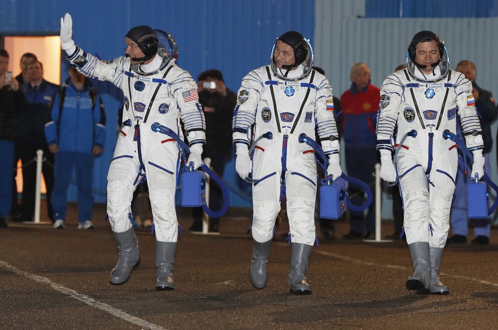 Trojice kosmonautů se loučí se zemí.