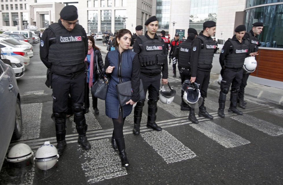 Lidé obcházejí policejní ozbrojence před budovou soudu v Istanbulu.