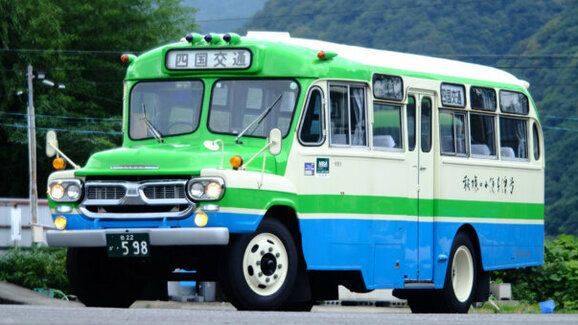 Lidé se skládají na opravu turistického autobusu do japonských hor