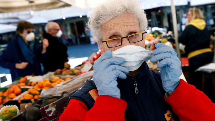Trhovec si upravuje ochrannou masku na náměstí Campo de Fiori v Římě
