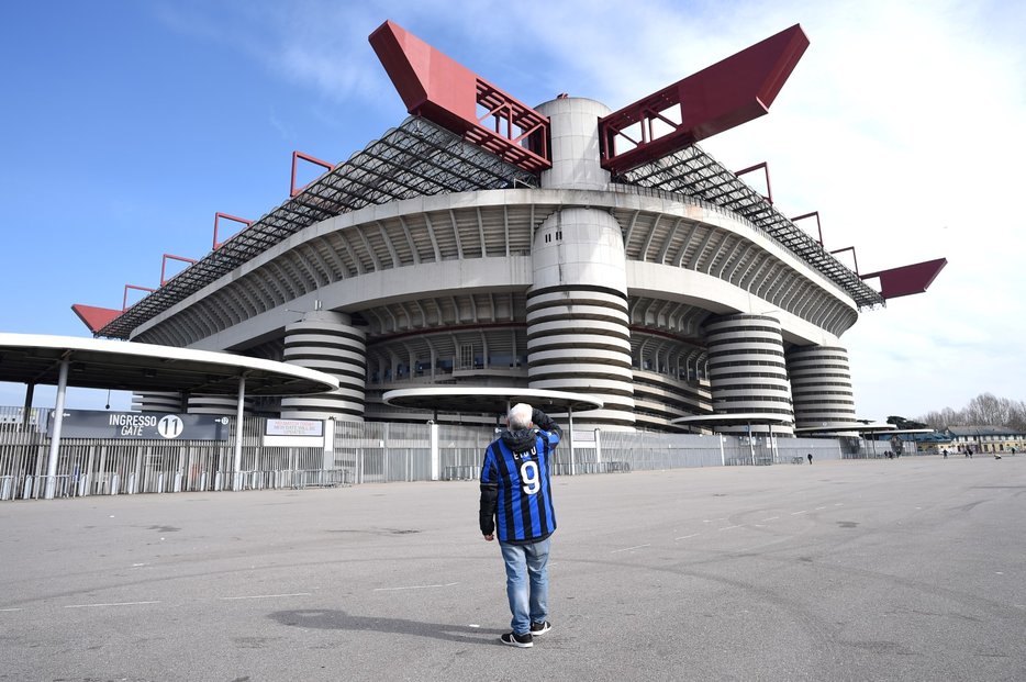 Muž stojící před San Sirem, stadionem dvou velkých fotbalových velkoklubů: AC Milán a Inter Milán. Kvůli koronaviru byl odložen zápas mezi Interem Milán a Sampdorií (23. 2. 2020)