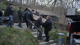Pohřební služba odnáší rakev s tělem Ivana Jonáka.