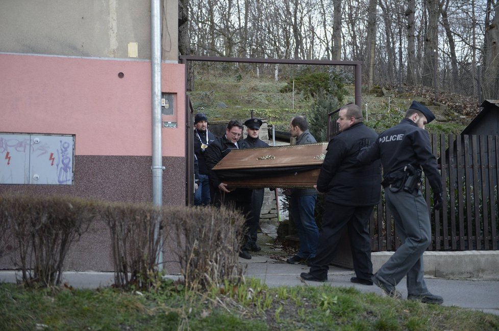 Pohřební služba odnáší rakev s tělem Ivana Jonáka.