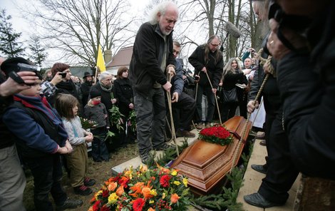 Zatímco přátelé z undergroundu rakev s Magorem spouštěli do hrobu, jeho družka s knězem (v pozadí) hráli Muchomůrky bílé.