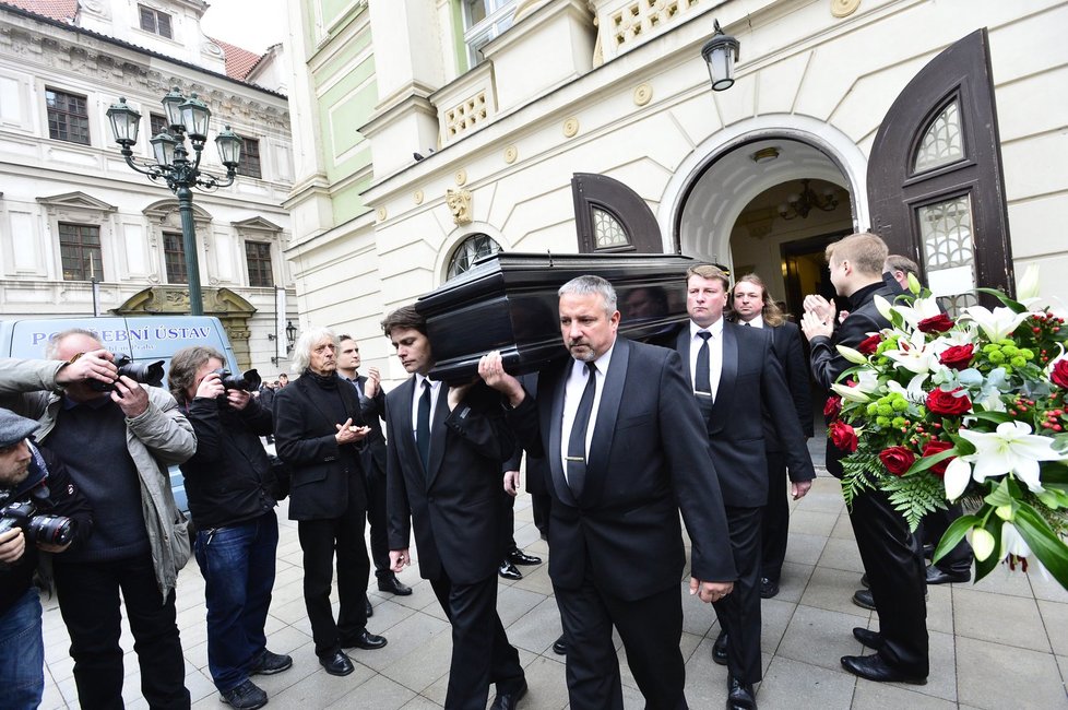 Muži vynášejí rakev s ostatky Ivana Rajmonta.