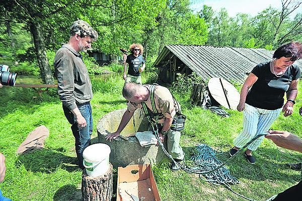 Kutilové z chat se vrahají na čištění studny. Myšička přihlíží, uvázaný Holub přehazuje nohu přes skruž...