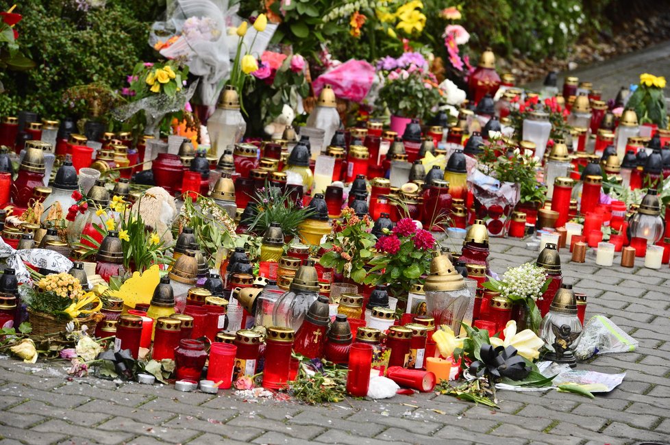 Svíčky, květiny a různé dárky nechávají fanoušci na chodníku před brankou.