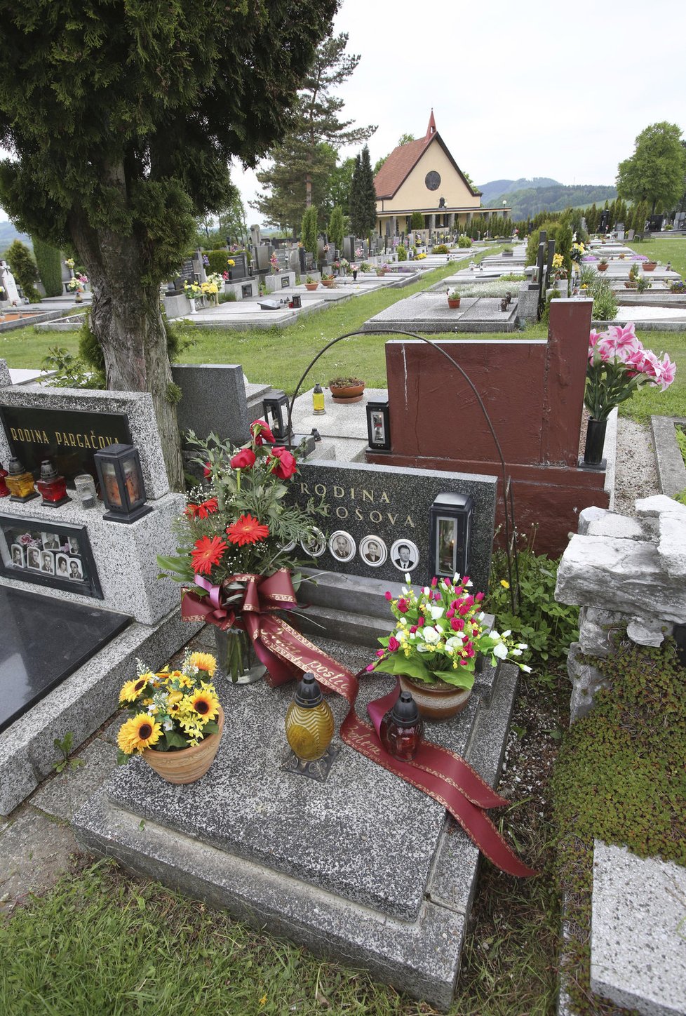 Na rodinné hrobce Bartošových je květina se smuteční stužkou.