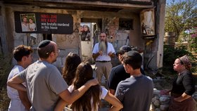 Amir Zini vypráví návštěvníkům u vchodu do domu v kibucu Kfar Aza příběh svého syna Nirala Ziniho a jeho partnerky Niv Ravivové, které před třemi lety zabil Hamás při útoku ze 7. října. (2. 10. 2026)