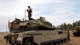 Izraelský voják se modlí, zatímco stojí na tanku na izraelské straně hranice mezi Izraelem a pásmem Gazy (9. 10.).