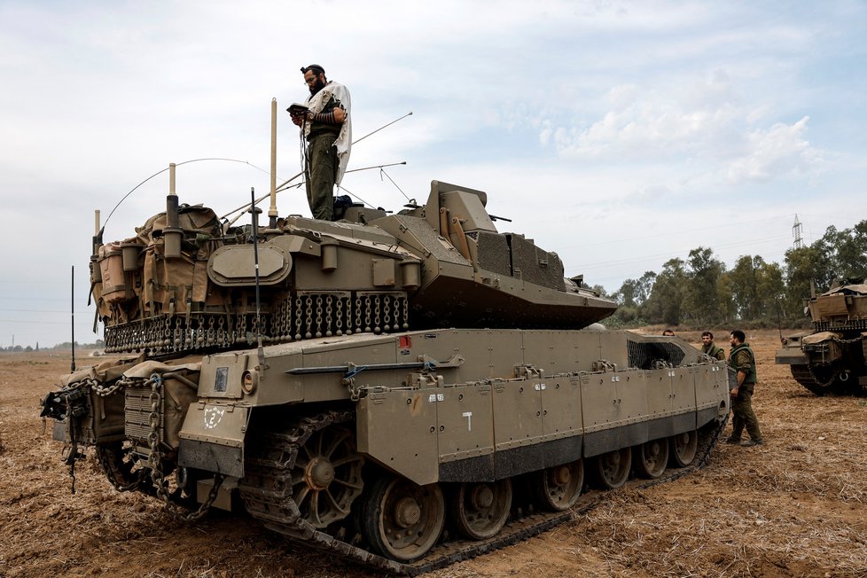 Izraelský voják se modlí, zatímco stojí na tanku na izraelské straně hranice mezi Izraelem a pásmem Gazy (9. 10.)