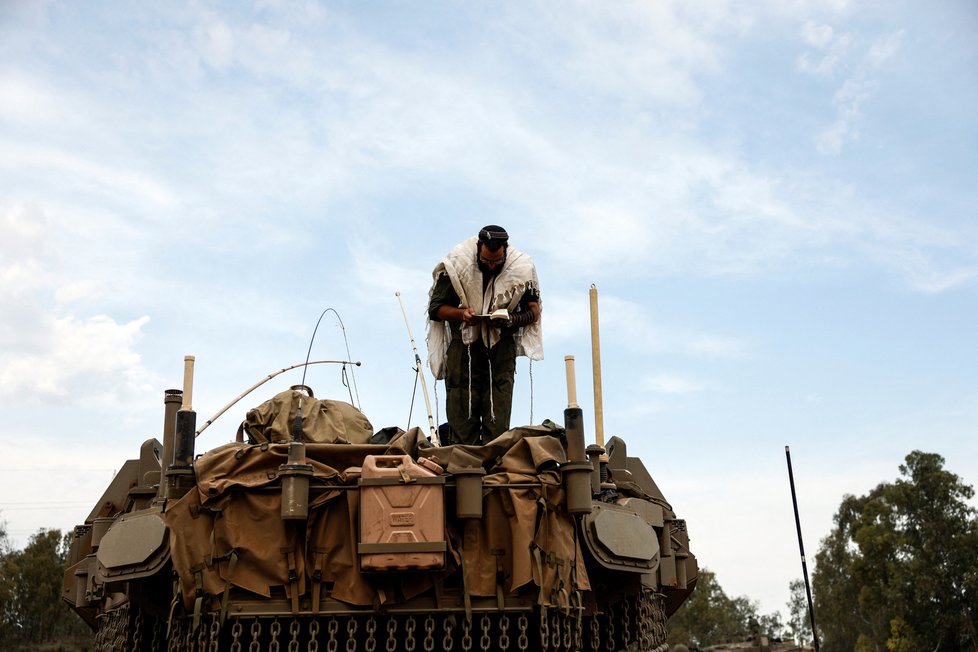 Izraelský voják se modlí, zatímco stojí na tanku na izraelské straně hranice mezi Izraelem a pásmem Gazy (9. 10.)