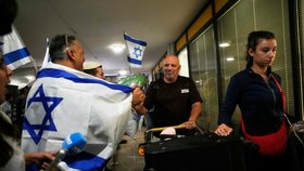 Příznivci krajně pravicové náboženské strany „Noam pro Izrael“ tančí a mávají izraelskými vlajkami, zatímco vítají izraelské cestující, kteří byli na palubě letadla společnosti FlyDubai, které nouzově přistálo v Saúdské Arábii