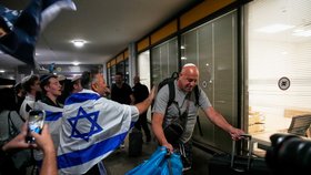 Příznivci krajně pravicové náboženské strany „Noam pro Izrael“ tančí a mávají izraelskými vlajkami, zatímco vítají izraelské cestující, kteří byli na palubě letadla společnosti FlyDubai, které nouzově přistálo v Saúdské Arábii