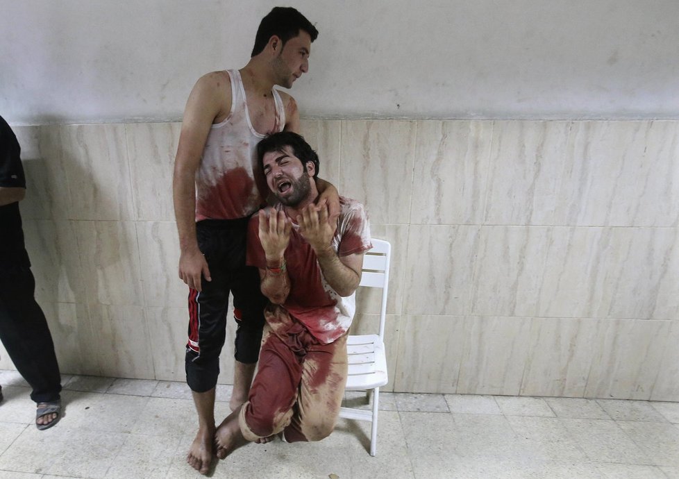 Drsné foto: Zkrvavení Palestinci v nemocnici v Khan Younis. Na sobě mají krev svého otce...