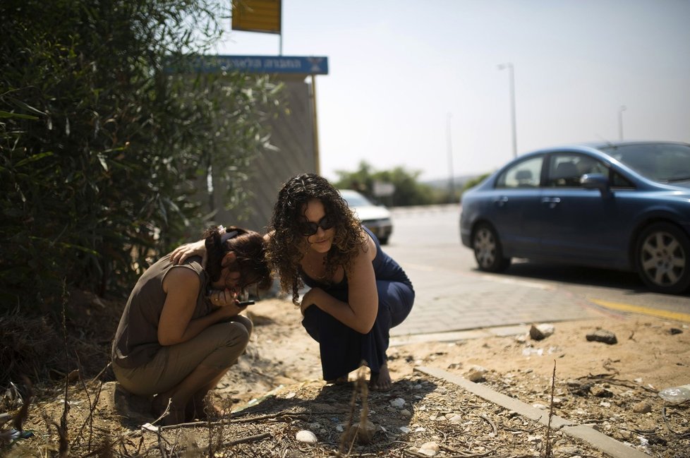 Dvě Izraelky v Ashkelonu se krčí poté, co zazněly sirény, varující před bombardováním ze strany Hamasu
