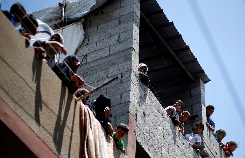 Palestinci sledující pohřeb Razan Al-Najar, palestinské zdravotní sestry, která zemřela při protestech na hranici Pásma Gazy.