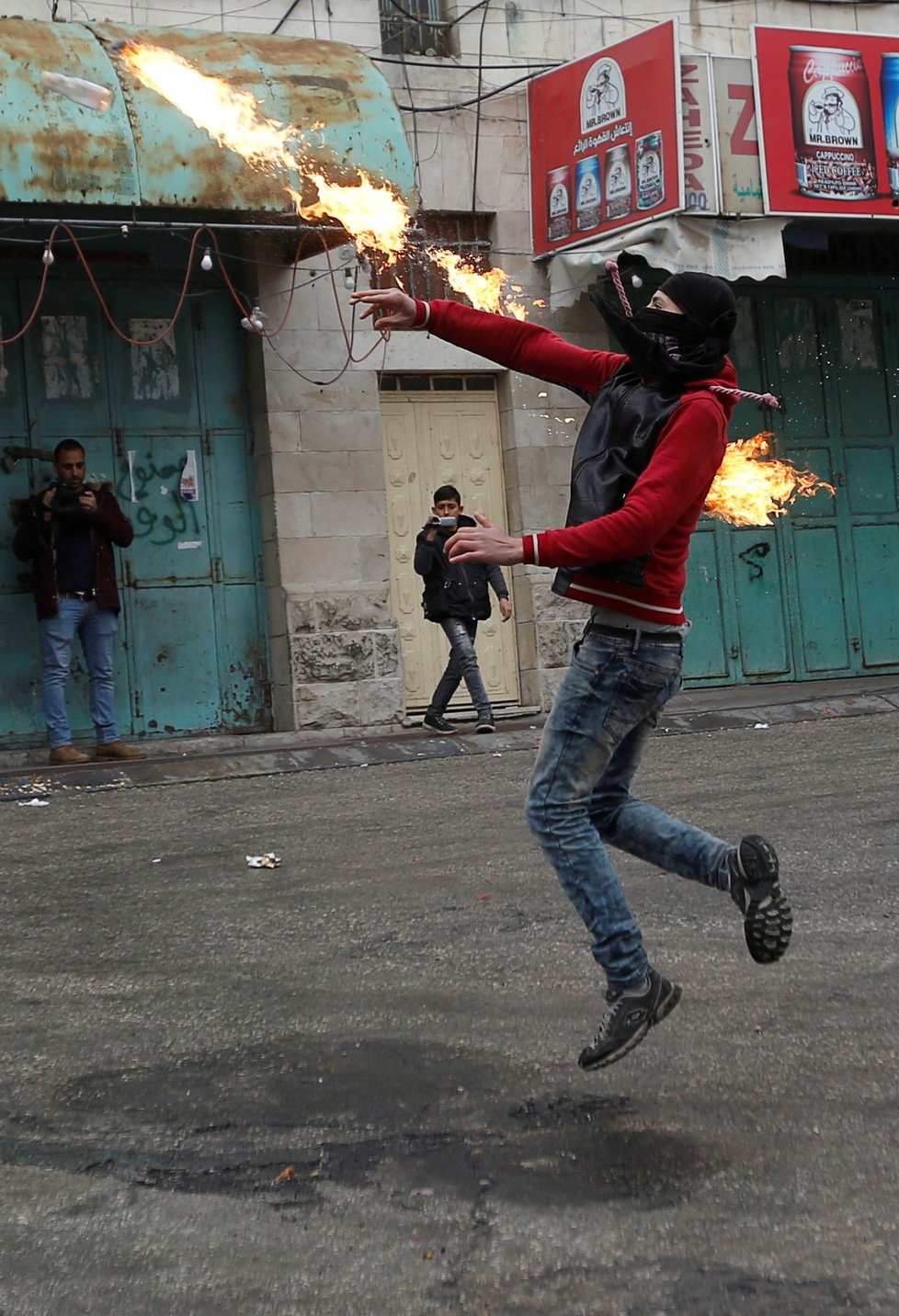 Palestinec hází molotovův koktejl na izraelské vojáky