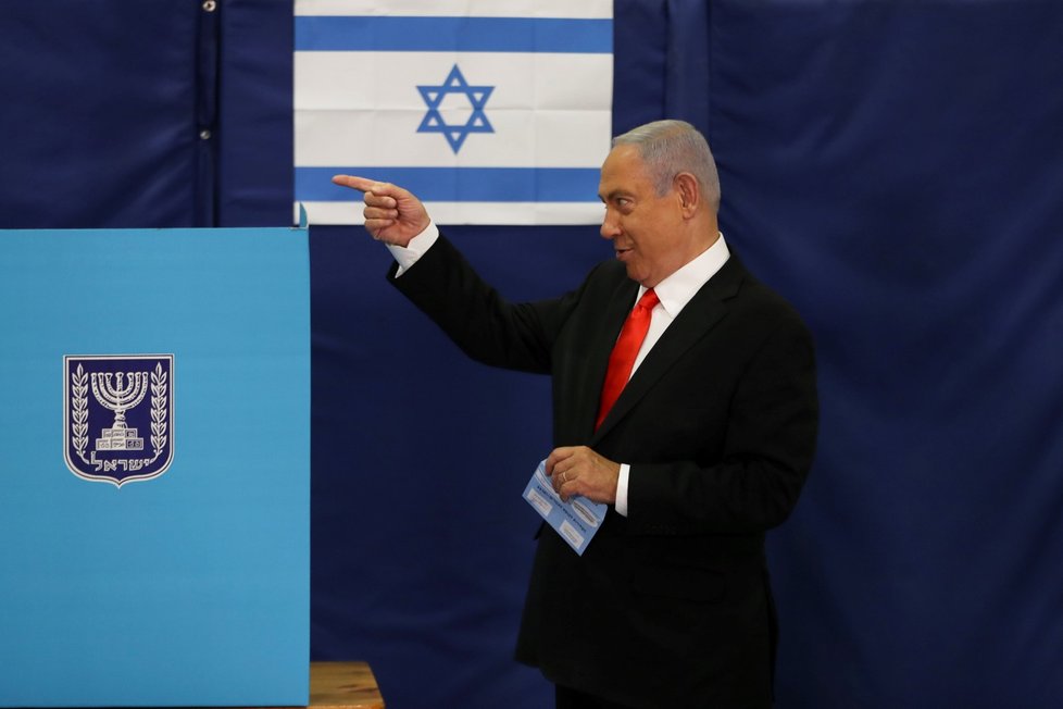 Premiér Benjamin Netanjahu ve volební místnosti.