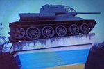 Svérázný protest. Tajemný Jack Obalovač zahalil do ukrajinských barev ve Starovičkách podstavec s ruským válečným tankem.