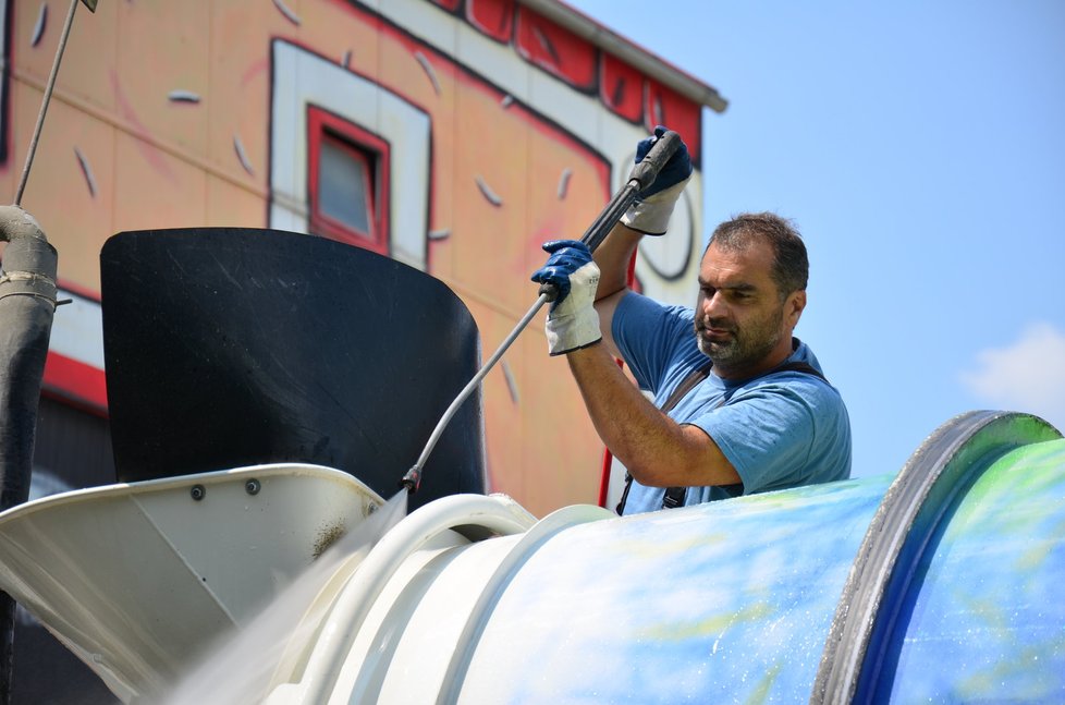 Radek Zrník si pak natočí koryto, kterým za pár okamžiků projede několik kubíků betonu. Než se tak ale stane, musí stavař transportní nádobu nastříkat olejem, aby z ní beton lépe klouzal. Na základně čeká mix důkladná očista. Kromě vody je použitý i hrubý štěrk. Ten se v bubnu smíchá s vodou. Pak je obsah vyprázdněn a štěrk se sítem oddělí a vrací zpět do sila. A protože i vypouštění šedivé břečky stroj zašpiní, musí být opět očištěn.