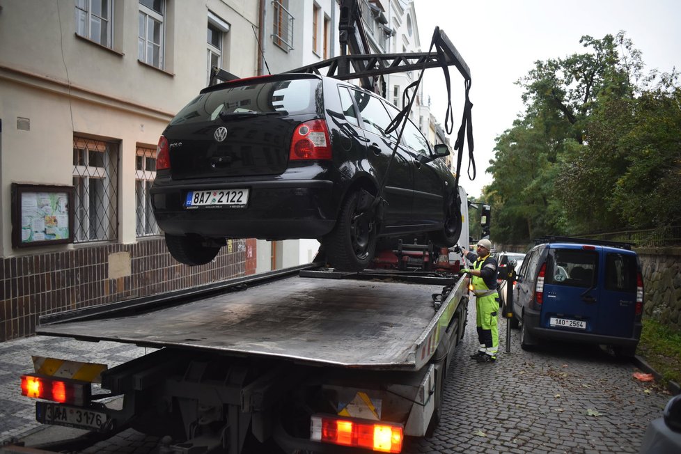 Při nakládání nepojízdného auta rukou vůbec nevadí, že je zaparkované natěsno v řadě