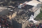Policisté a záchranáři prozkoumají místo výbuchu v továrně v Tangerangu na okraji Jakarty v Indonésii. Výbuch a zuřivý požár zabil řadu lidí a desítky zranil, uvedla policie.
