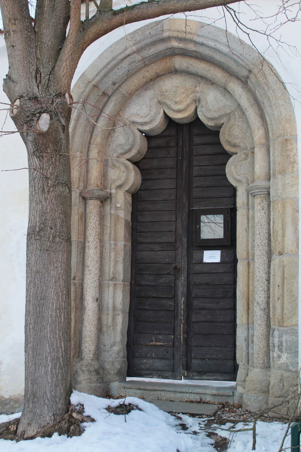 Portál v nynější hřbitovní zdi zřejmě krášlil vstup do menšího laického kostela