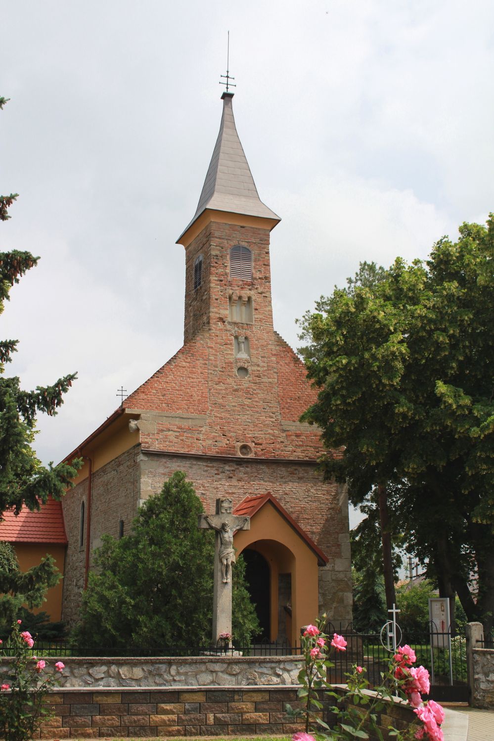 Průčelí kostela v Boldogu. Tu jsou krásně patrné pozdější dostavby štítu i věže.